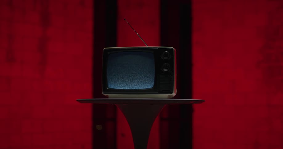 A vintage television with fuzz on the screen sitting on a table