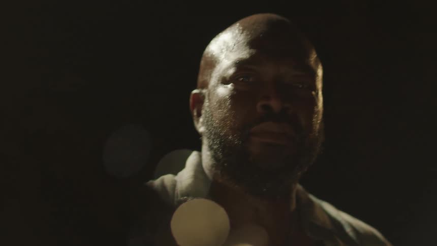 Close up of the bearded face of a nervous man at night