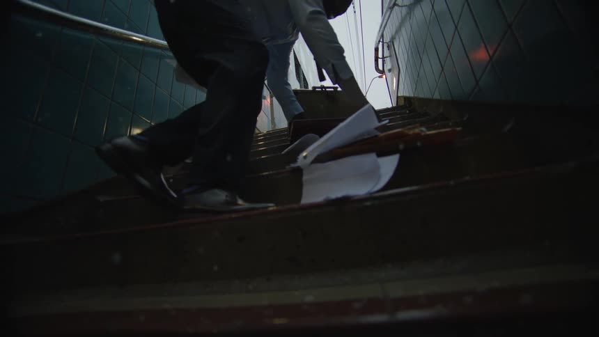 A man spills the contents of his briefcase as he climbs the steps