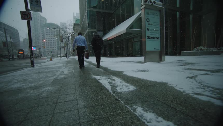 Two people are walking through the city in winter