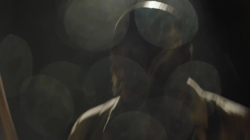 A man is sweating as he plays the drums