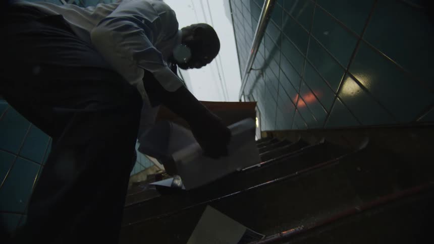 A man spills all his belongings from the briefcase on the stairs