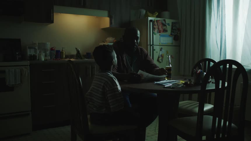 A son shows his father a drawing