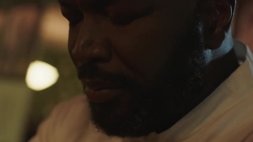 A man sitting in a room looking sad with flashing lights