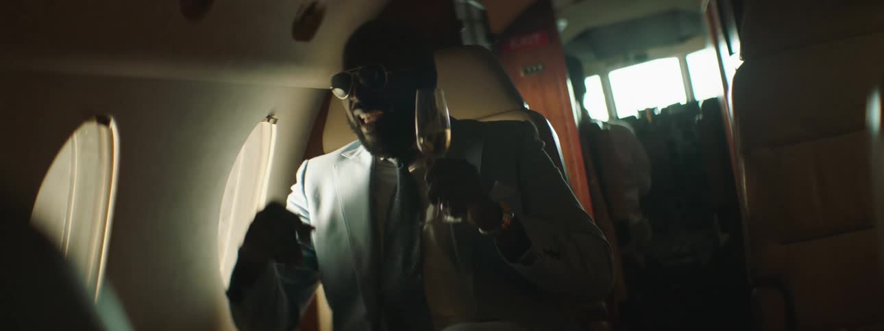 A man sneezes and spills his drink on the plane