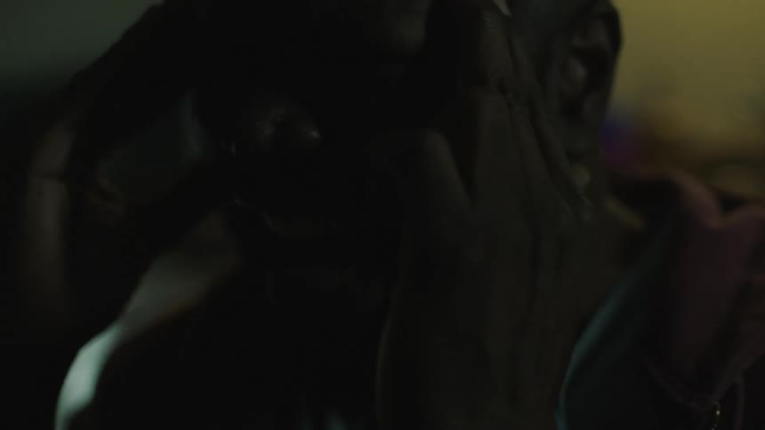 A man screams in pain as lights flash on him