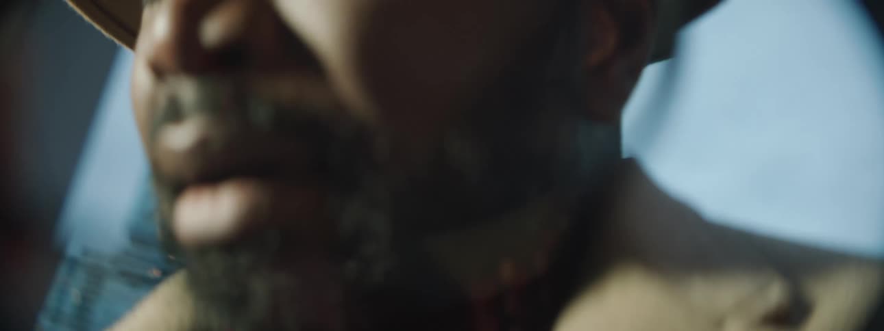 Close up of a mans face as he stands in front of skyscrapers
