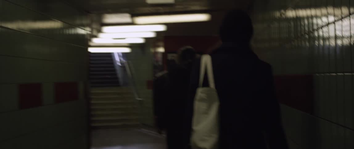 People are walking down a narrow hall