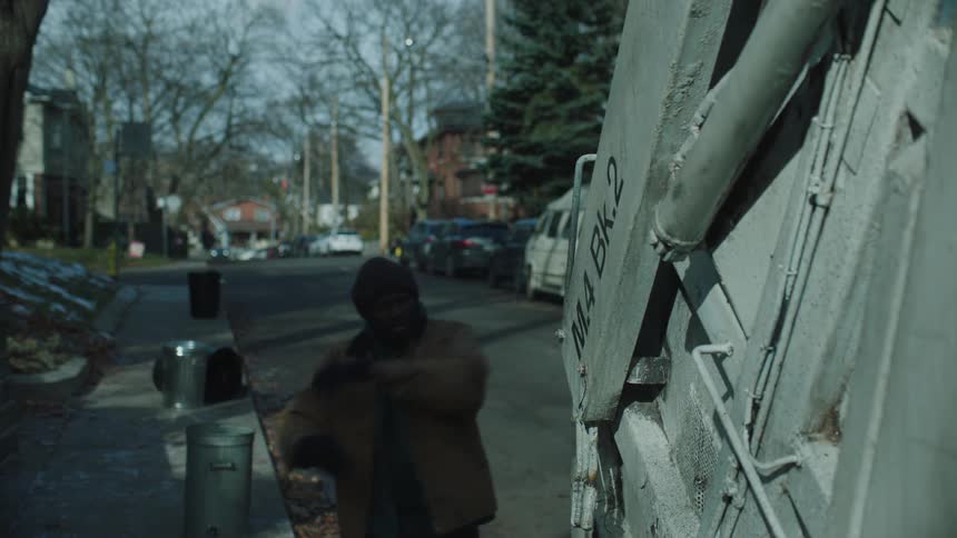 A garbage man tosses bags into the truck