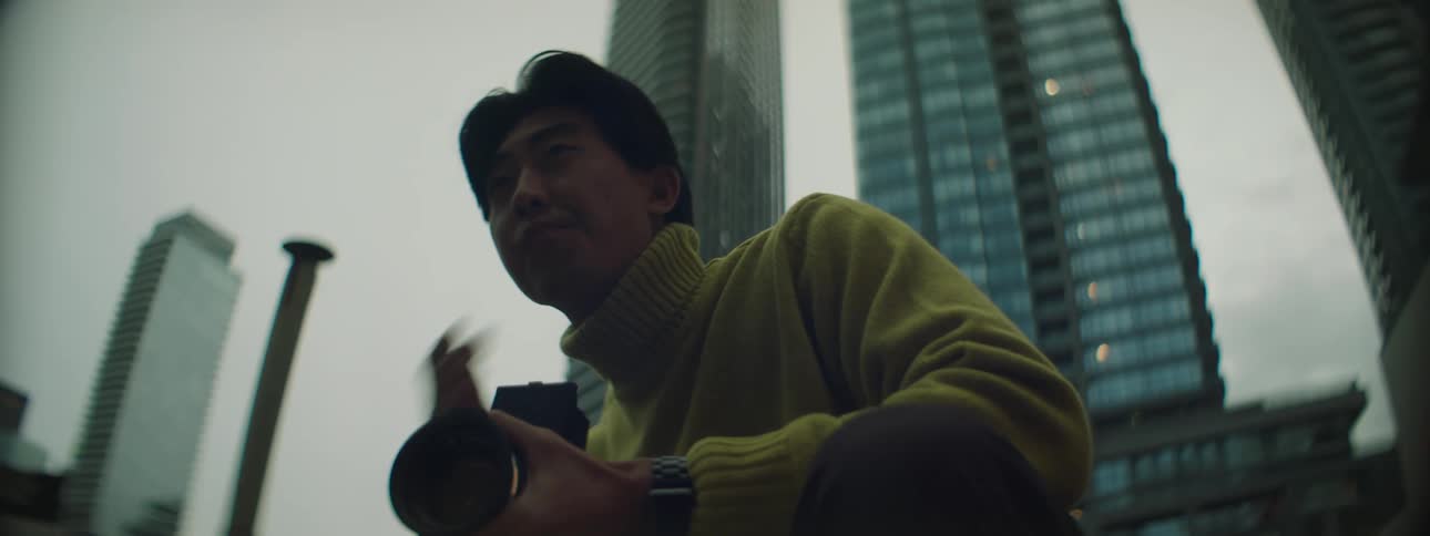 Photographer guides subject with gestures as he takes pictures downtown