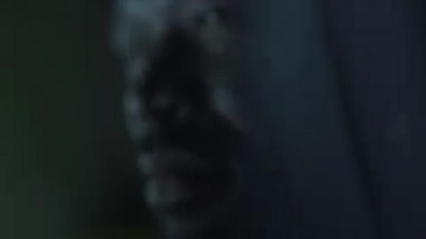 Close up of a mans face as lights flash on him