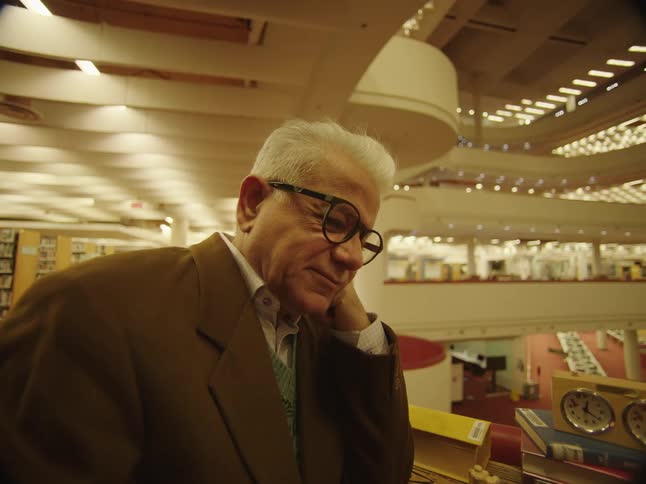 A man leans on the counter in the library