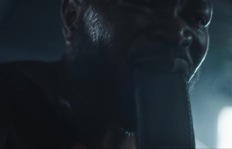 A fighter tightens his glove by pulling the strap with his teeth