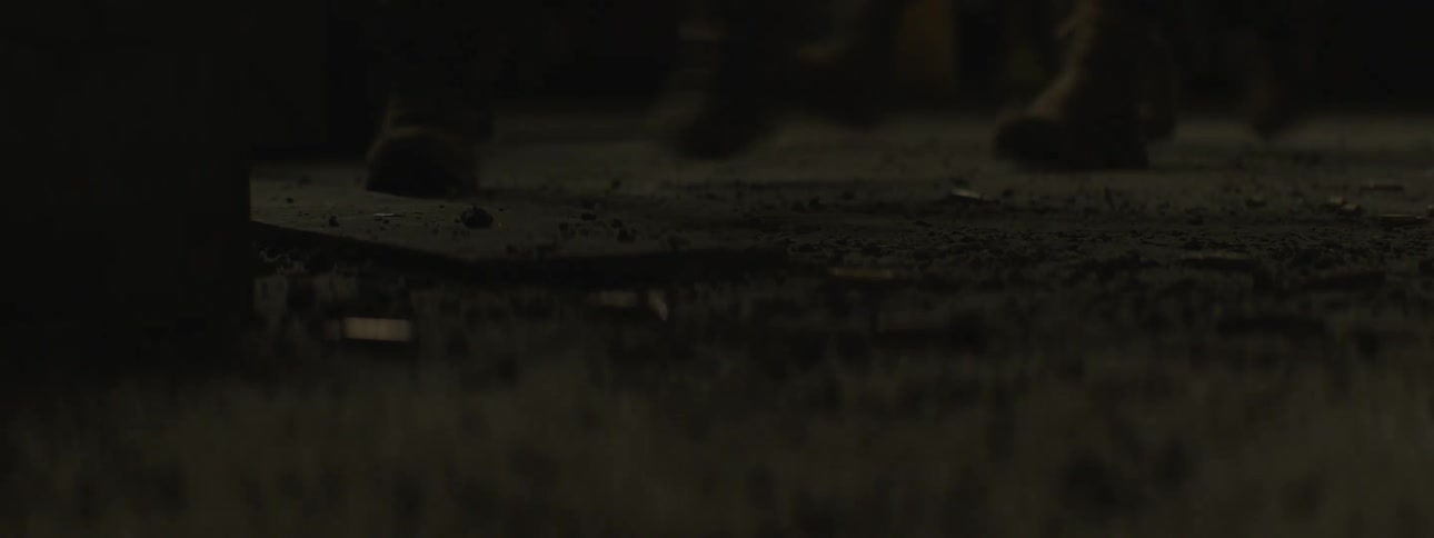 View from under an object of a group of peoples feet wearing boots passing by