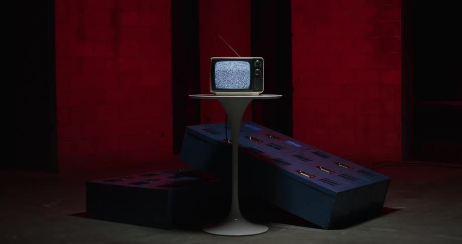 A television is sitting on a table and static is on the screen