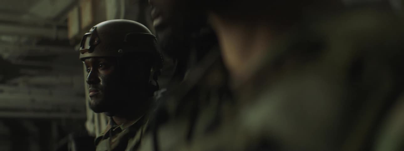 Soldiers in helmet and fatigues stand near carved building support column