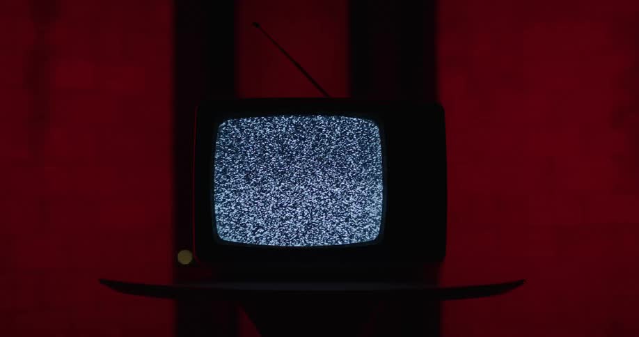 Vintage television with white static and flashing displayed on a round table
