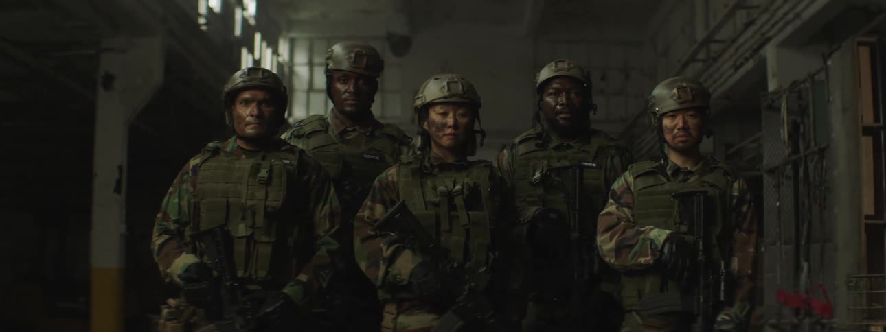 Group of soldiers standing next to each other looking at the camera inside an abandoned building
