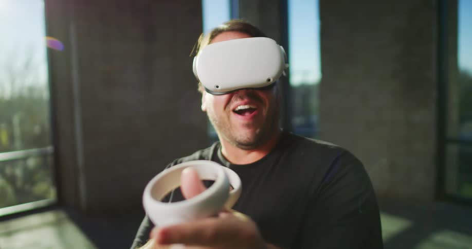 A man is playing a virtual reality game indoors during the day