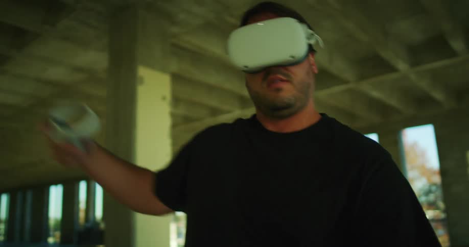 A man plays a vr game inside a building under construction