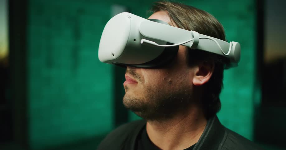 Man standing inside a room looking around using virtual reality goggles