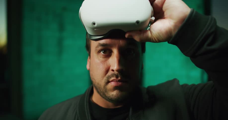 Closeup of man lifting up virtual reality headset hes wearing
