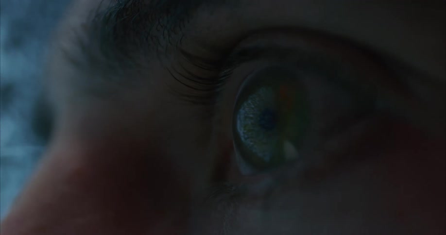 Close up of a persons eye as they look at a fuzzy television screen