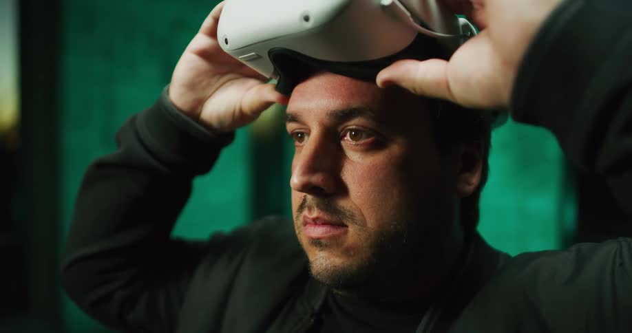 Young man pulls virtual reality vr goggles up and down his eyes