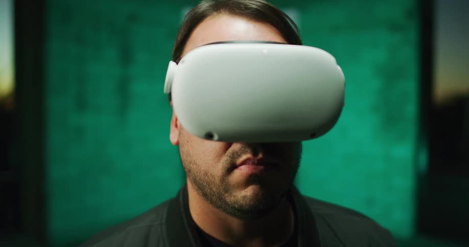 Man standing inside a room looking around using virtual reality vr goggles
