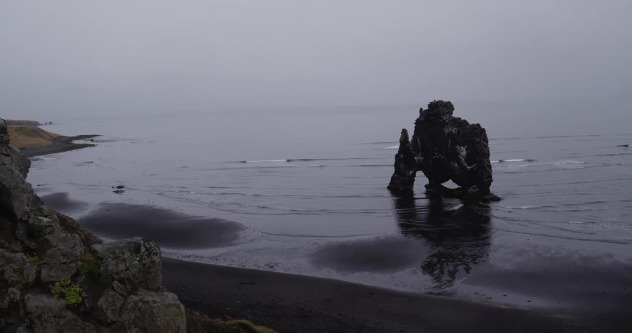 A small rock formation sits close to the shore