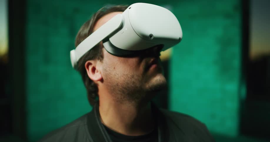 A man moves his head around in different directions while wearing a virtual reality headset