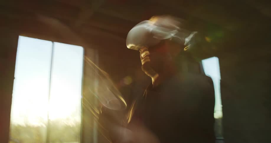 A man is playing virtual reality by the window