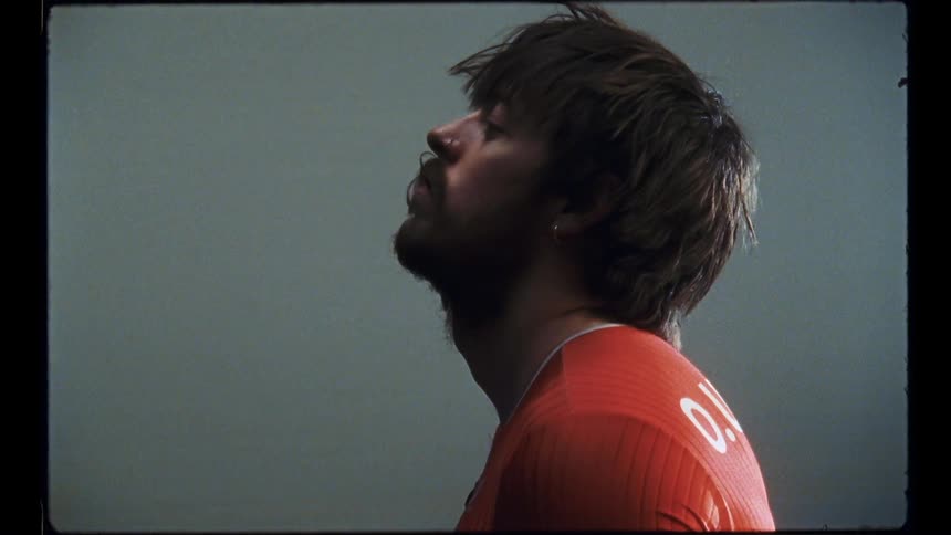 A man stretches his neck while standing in his prison cell