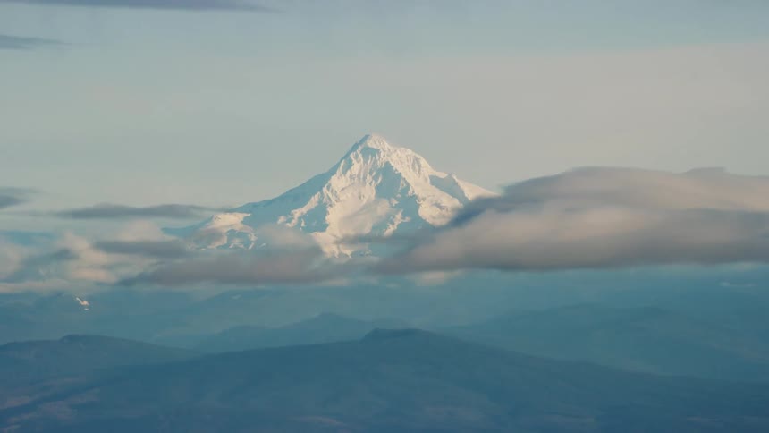 Bumpy shot of massive snow covered mountain from airplane window