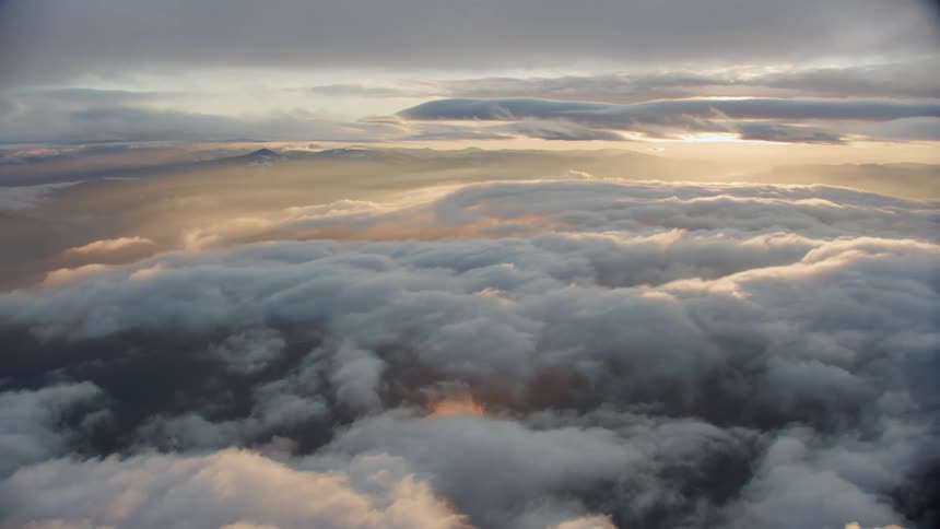 Stunning sunset flight over clouds over a pristine and untouched landscape