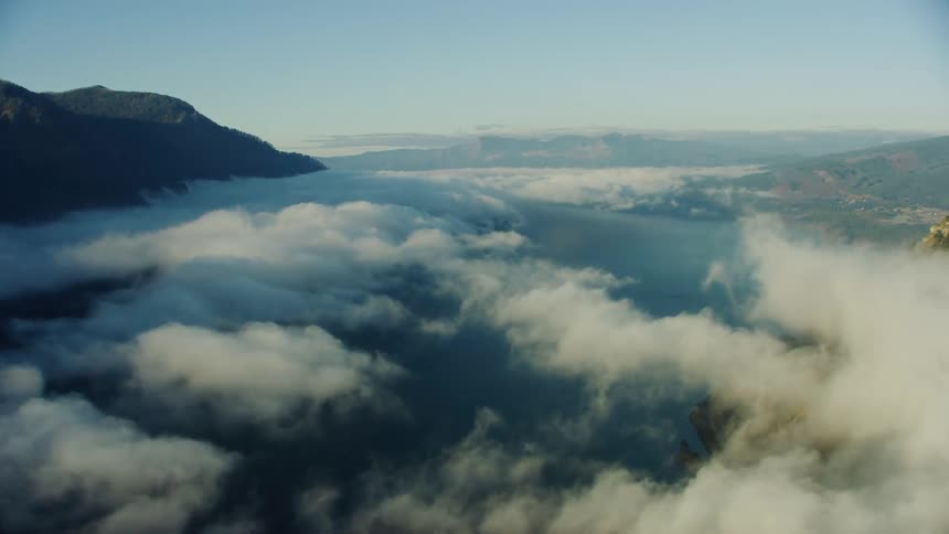 Hyperlapse time lapse flying just above clouds over a vast river valley