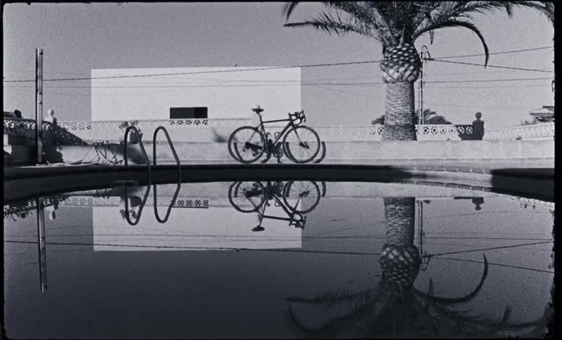 A bicycle is sitting next to a pool in a residential area