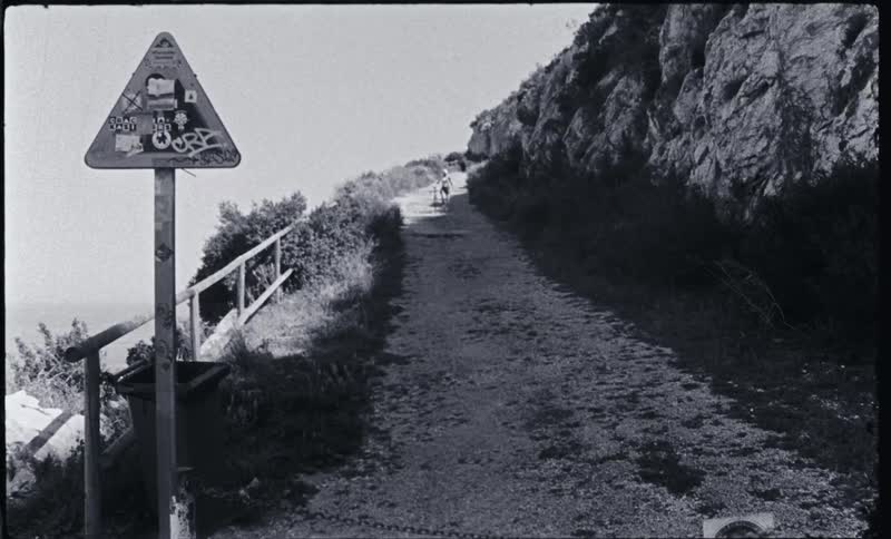 A person is pushing their bicycle on the trail