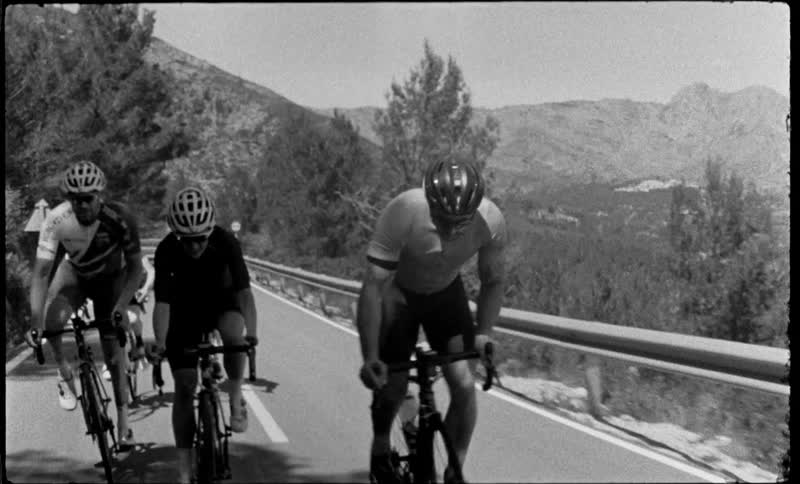 A group of people riding bicycles up a hill