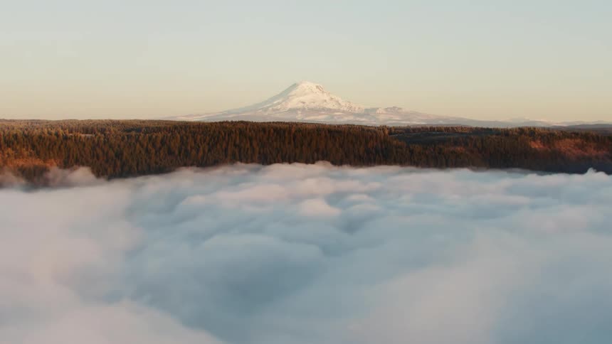 Hyper Lapse Time Lapse over dense fog covered valley revealing massive snow covered Mount Adams in Washington State