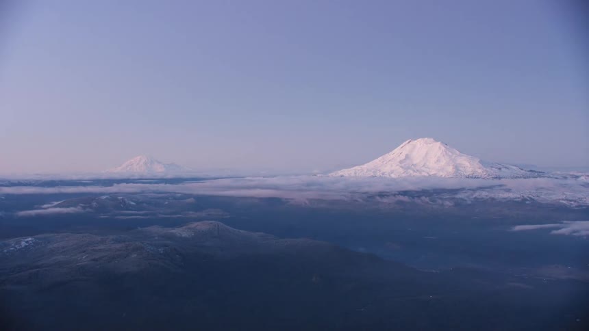 Commercial Jetliner view of Mount Adams and Mount Rainier as airplane flies into Portland