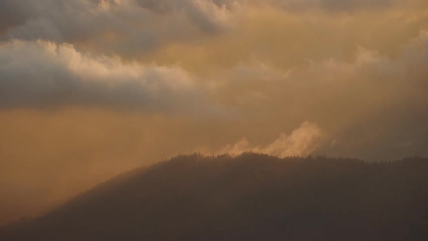 Clouds blow off steep ridge as seen from commercial jetliner