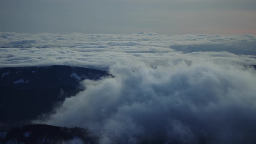 Hyperlapse shot of thick rolling fog passing over a mountain ridge creating a stunning effect