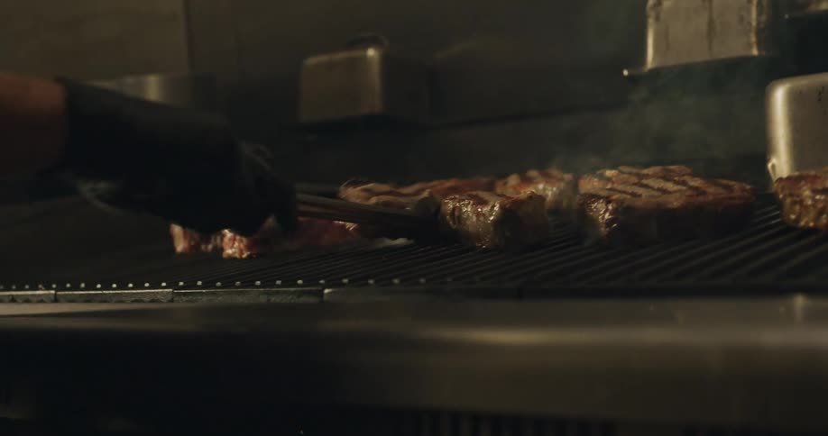 A person grills meat in a restaurant
