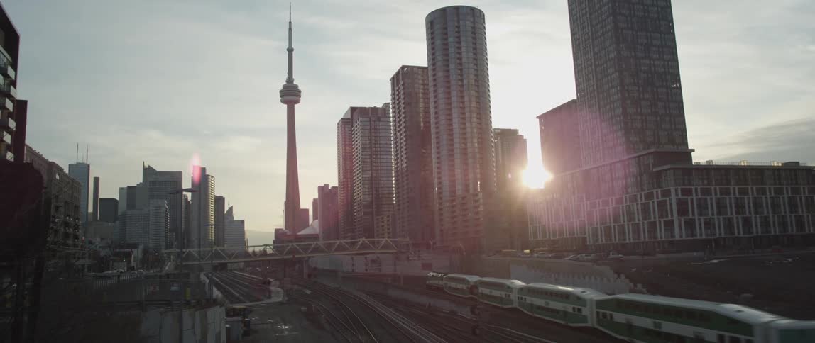 A train moves down the tracks in a city