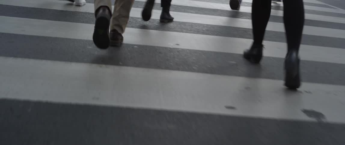 Feet crossing the road in busy city