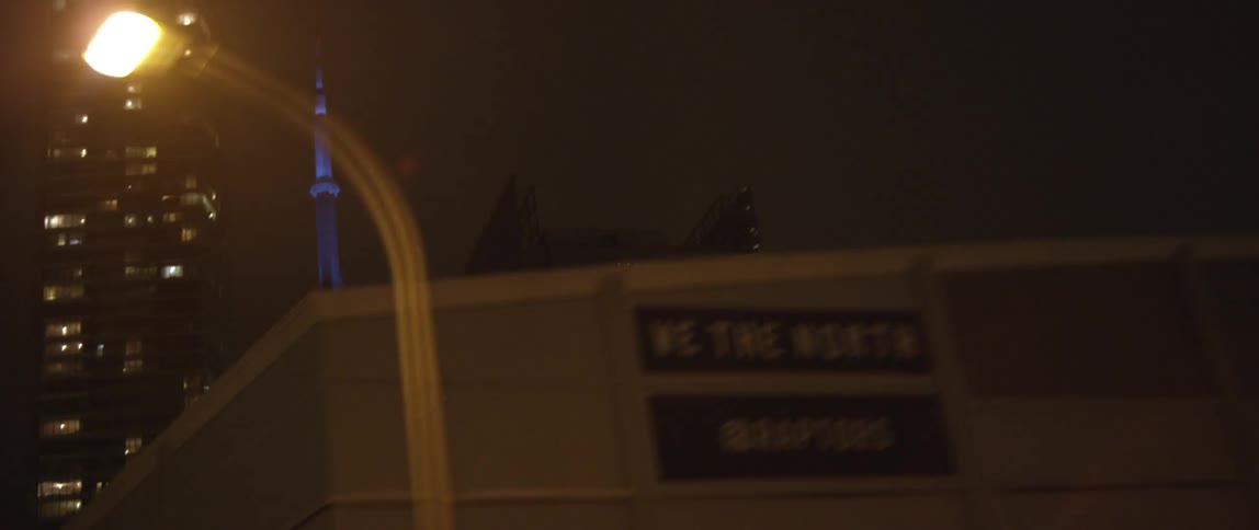 Moving past some buildings in a city at night
