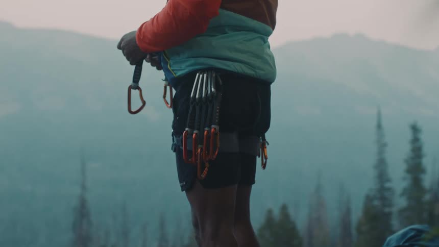 Man wearing mountaineering equipment gearing up near the mountains at morning