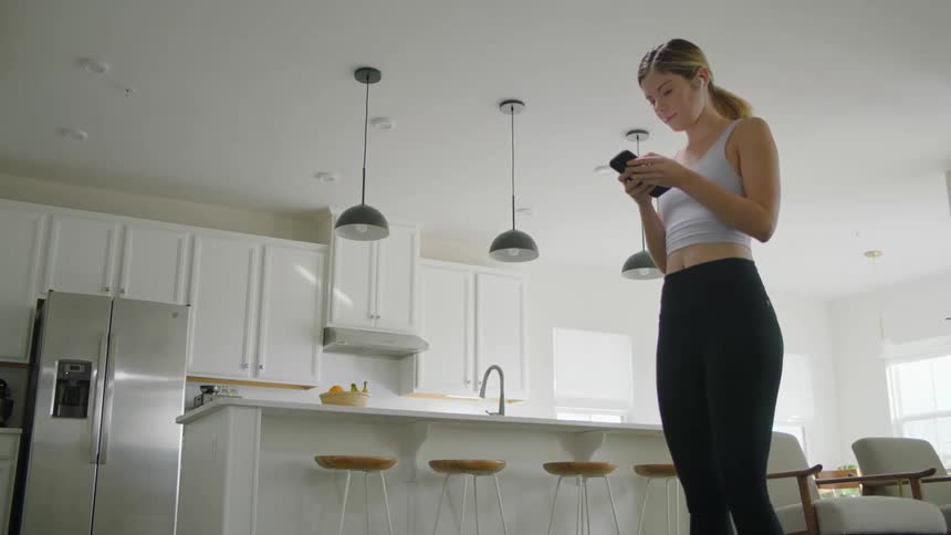 A woman is typing on her phone at home
