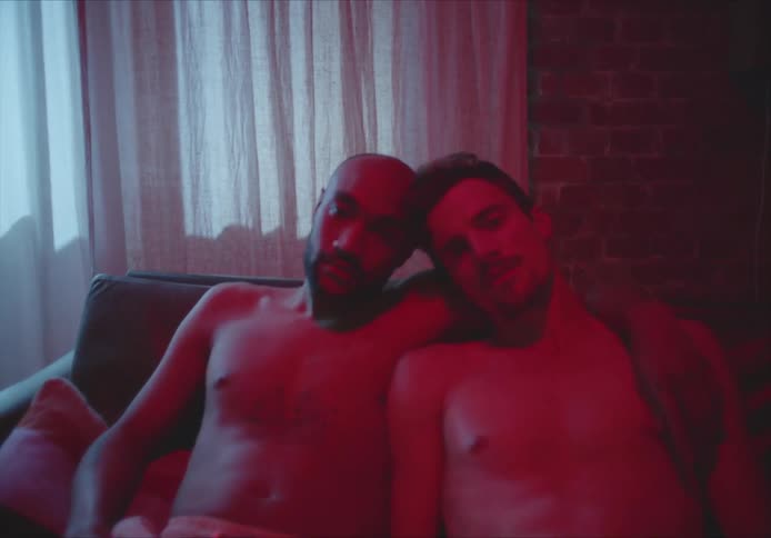 A portrait of two men on a couch together